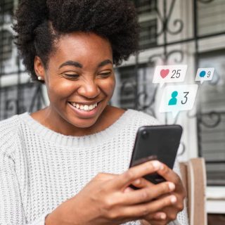woman using her phone and smiling